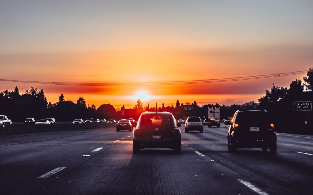 Cars driving on freeway at sunset